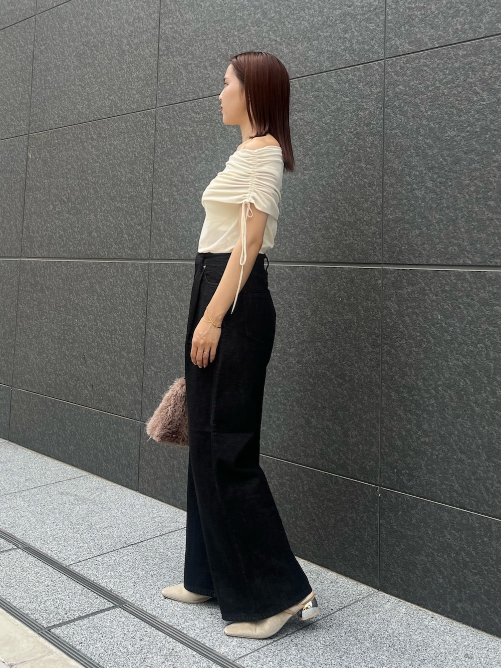 ホワイト系のTシャツ/カットソー、ブラック系のデニムパンツ、ベージュ系のパンプスを着用したレディースの夏コーディネートの2枚目の写真