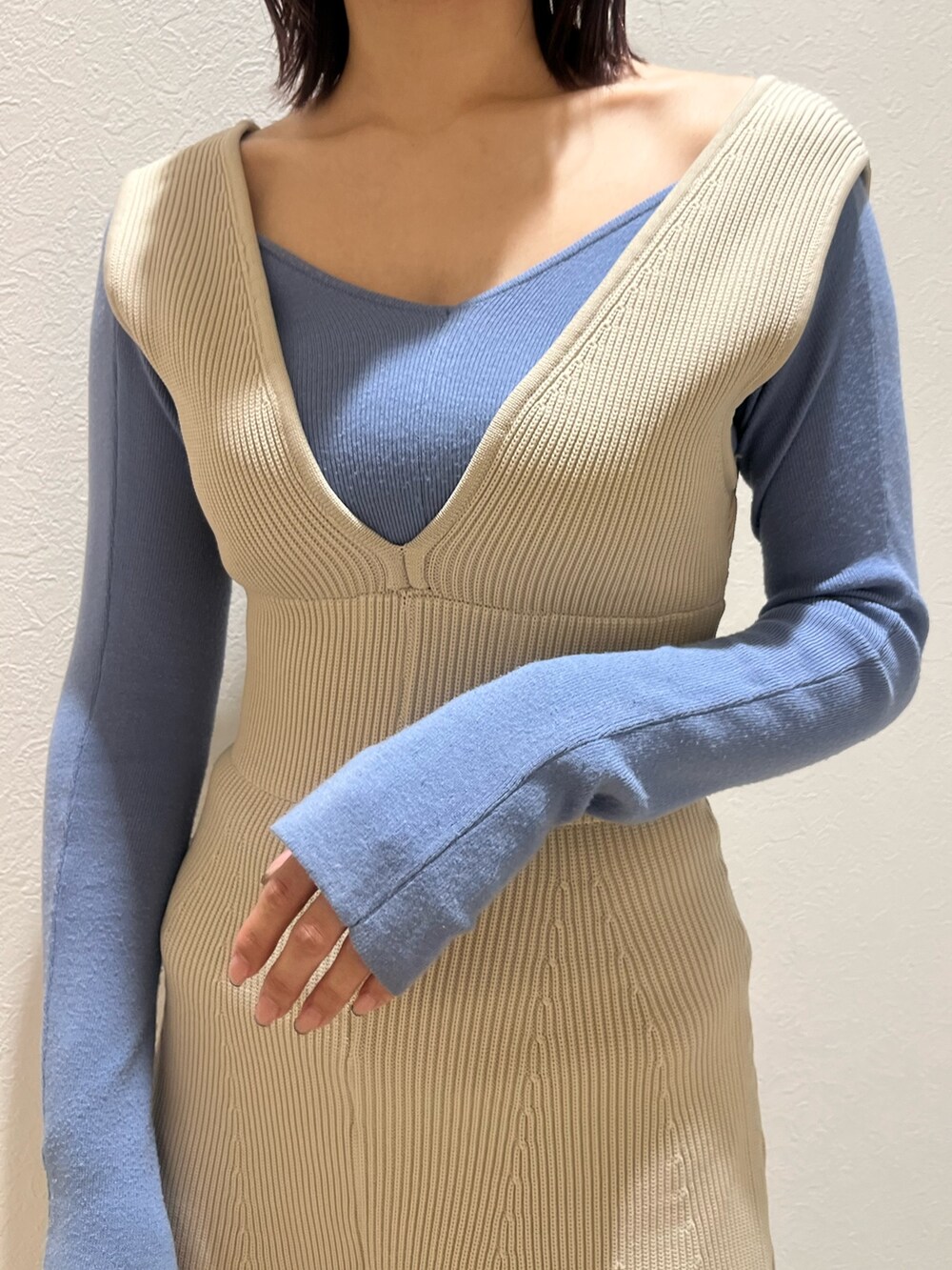 ブラック系のブーツ、ホワイト系のジャンパースカート、ブルー系のニット/セーターを着用したレディースの冬コーディネートの5枚目の写真