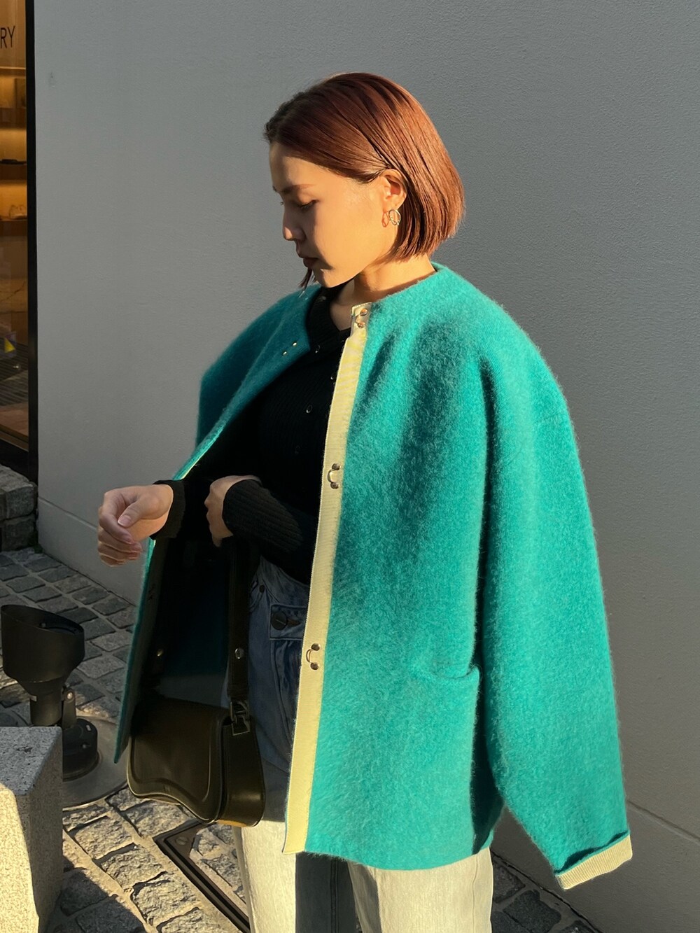 ブルー系のデニムパンツ、ブルー系のカーディガン/ボレロ、ブラック系のニット/セーターを着用したレディースの冬コーディネートの6枚目の写真