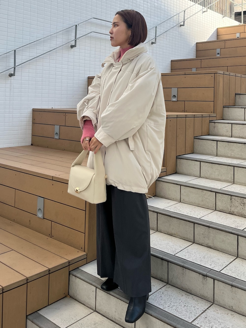 グレー系のその他パンツ、ホワイト系のハンドバッグ、ホワイト系のダウンジャケット/コートを着用したレディースの冬コーディネートの4枚目の写真