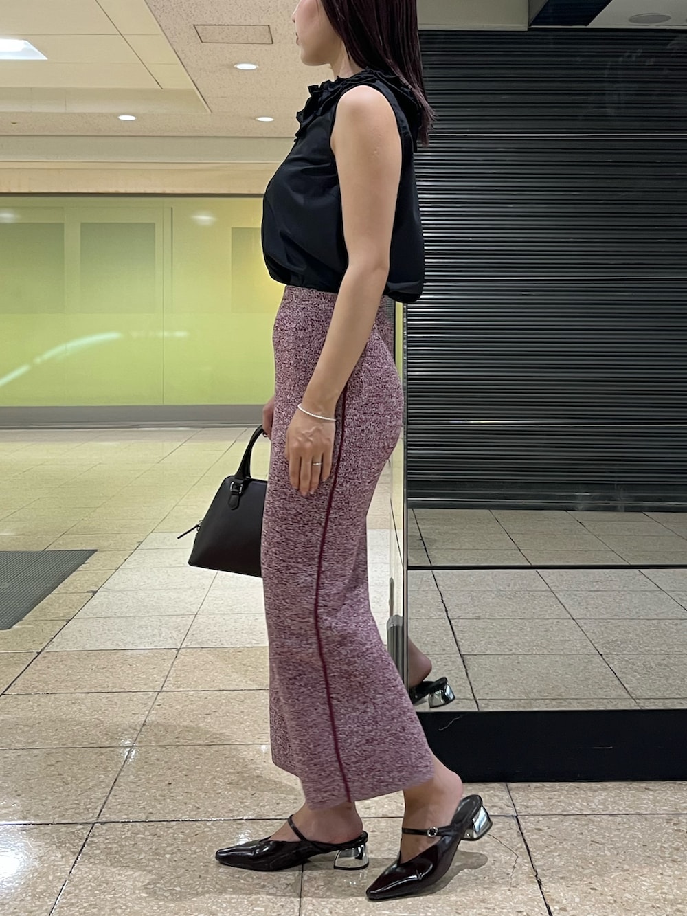 レッド系のワンピース、ブラウン系のボストンバッグ、ブラウン系のパンプスを着用したレディースの夏コーディネートの2枚目の写真