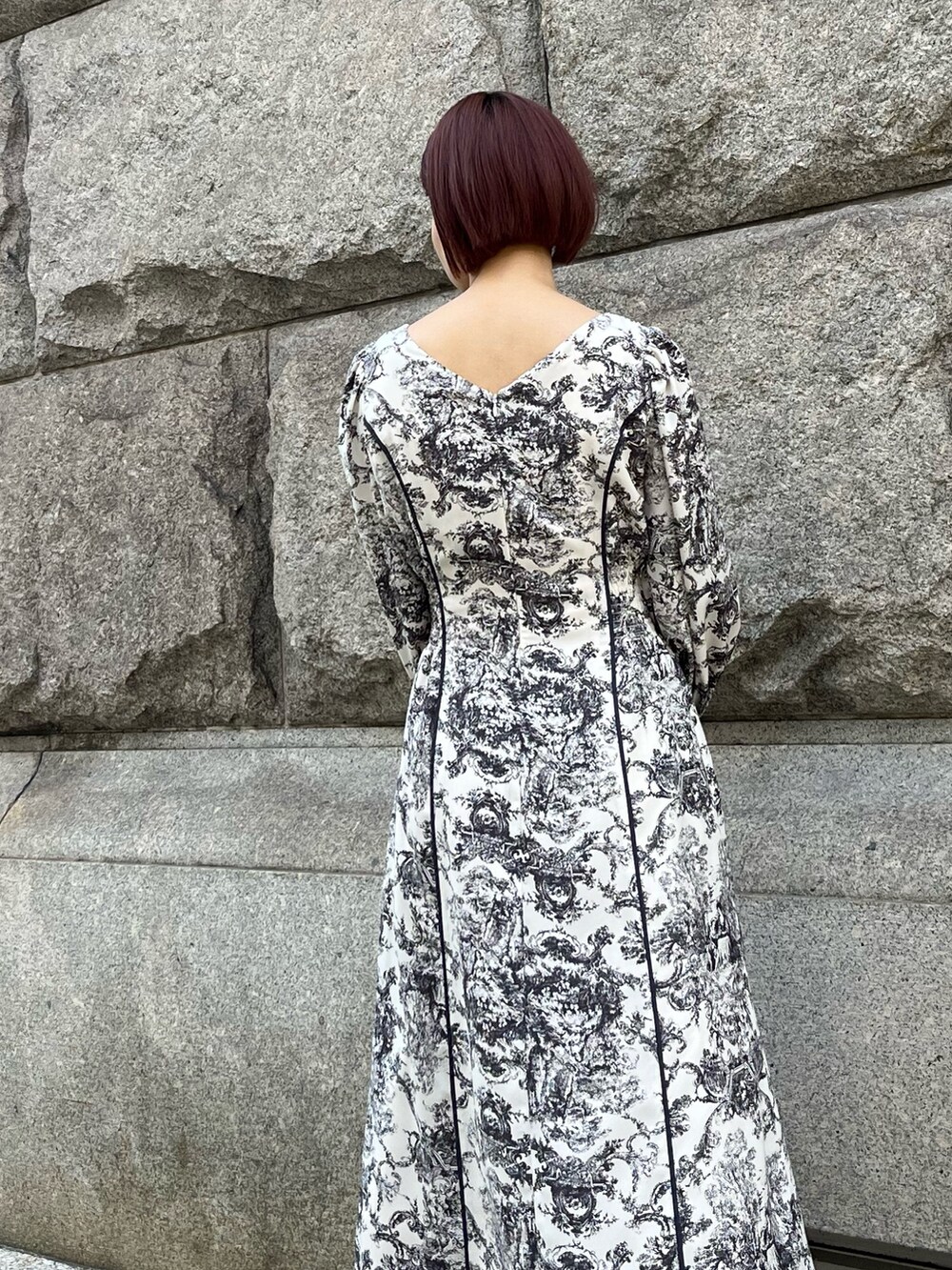 ホワイト系のワンピース、ブラック系のハンドバッグ、ブラック系のブーツを着用したレディースの冬コーディネートの6枚目の写真