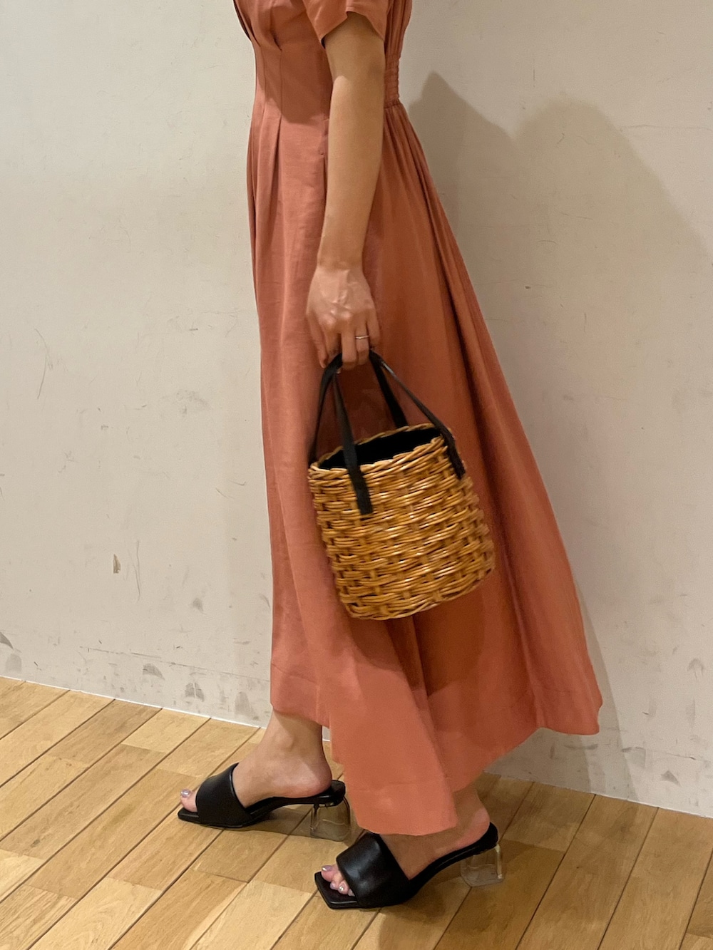 ブラウン系のハンドバッグ、ブラック系のサンダル、ピンク系のワンピースを着用したレディースの夏コーディネートの4枚目の写真