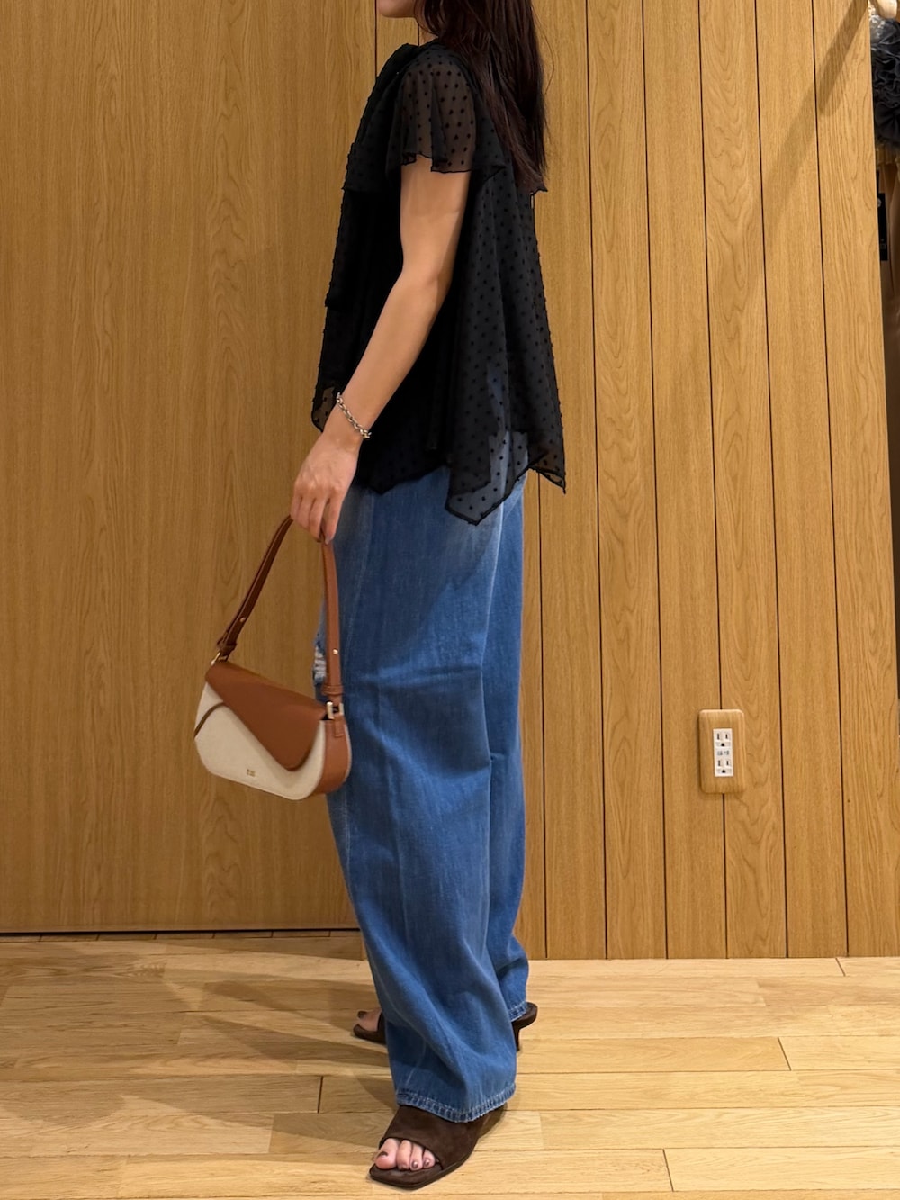 ブルー系のデニムパンツ、ブラウン系のサンダル、ブラウン系のハンドバッグを着用したレディースの春コーディネートの2枚目の写真