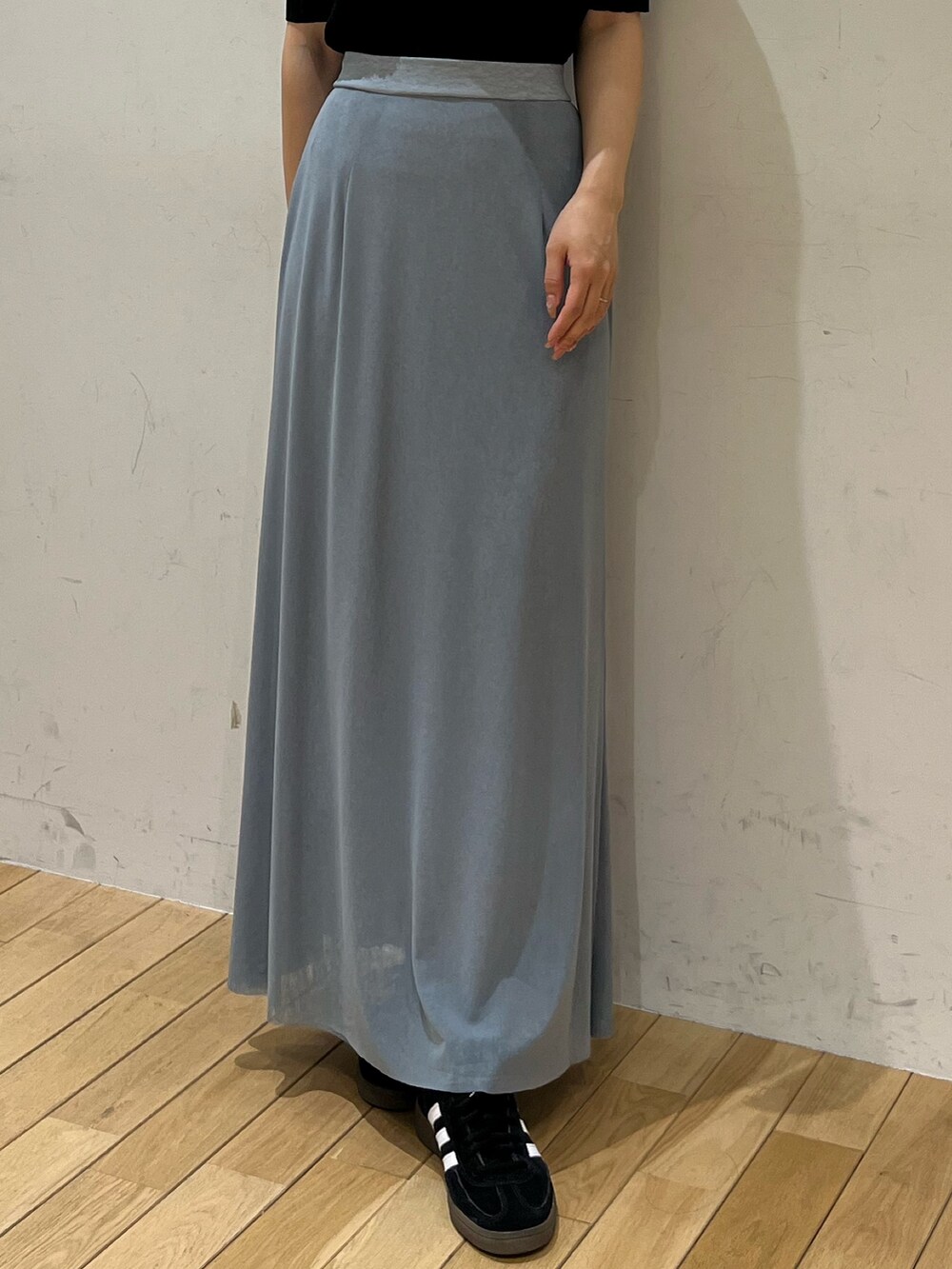 ブルー系のスカート、ブラック系のTシャツ/カットソー、ブラック系のスニーカーを着用したレディースの春コーディネートの6枚目の写真