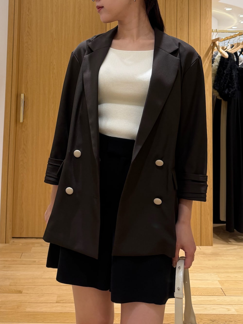 ブラック系のその他パンツ、ブラウン系のテーラードジャケット、ホワイト系のハンドバッグを着用したレディースの春コーディネートの4枚目の写真