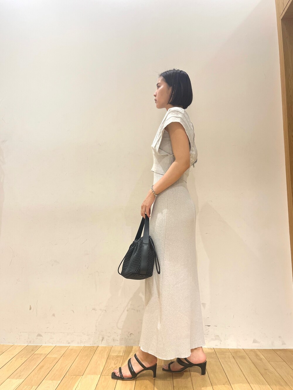 ベージュ系のハンドバッグ、ブルー系のワンピースを着用したレディースの夏コーディネートの3枚目の写真