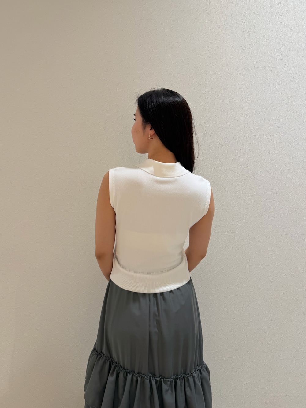 ホワイト系のワンピース、ブラック系のハンドバッグ、ブラック系のパンプスを着用したレディースの夏コーディネートの5枚目の写真