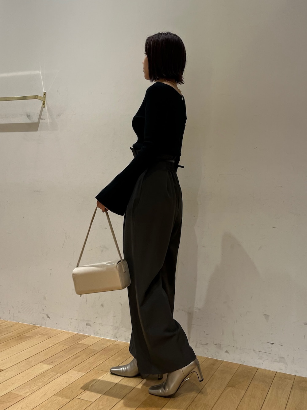 グレー系のその他パンツ、シルバー系のブーツ、ホワイト系のショルダーバッグを着用したレディースの秋コーディネートの2枚目の写真