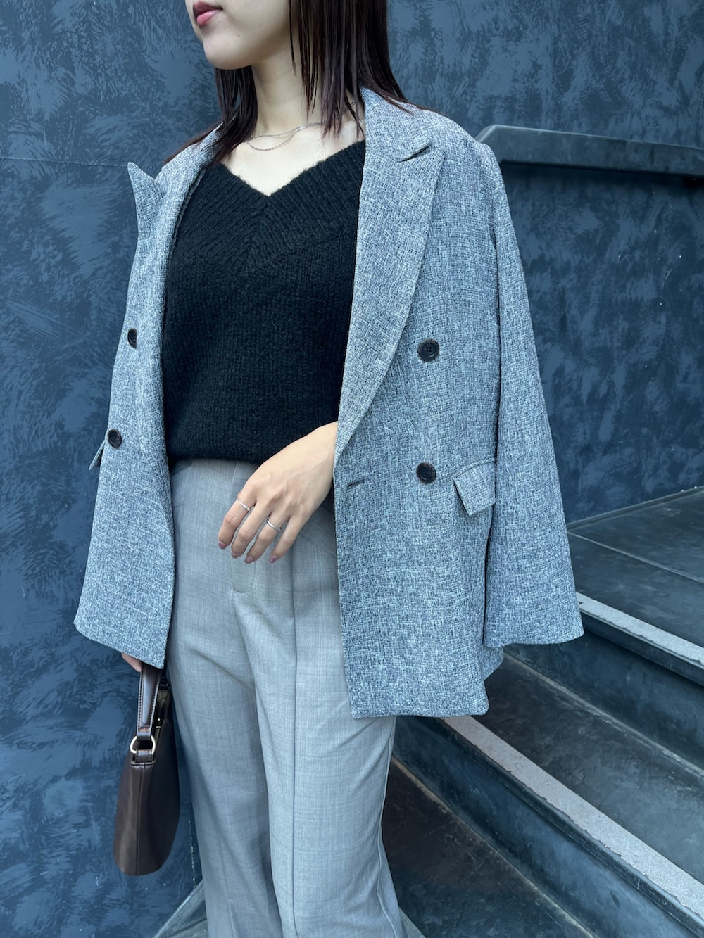 ブラック系のニット/セーター、ブラウン系のハンドバッグ、ブラック系のブーツを着用したレディースの冬コーディネートの5枚目の写真