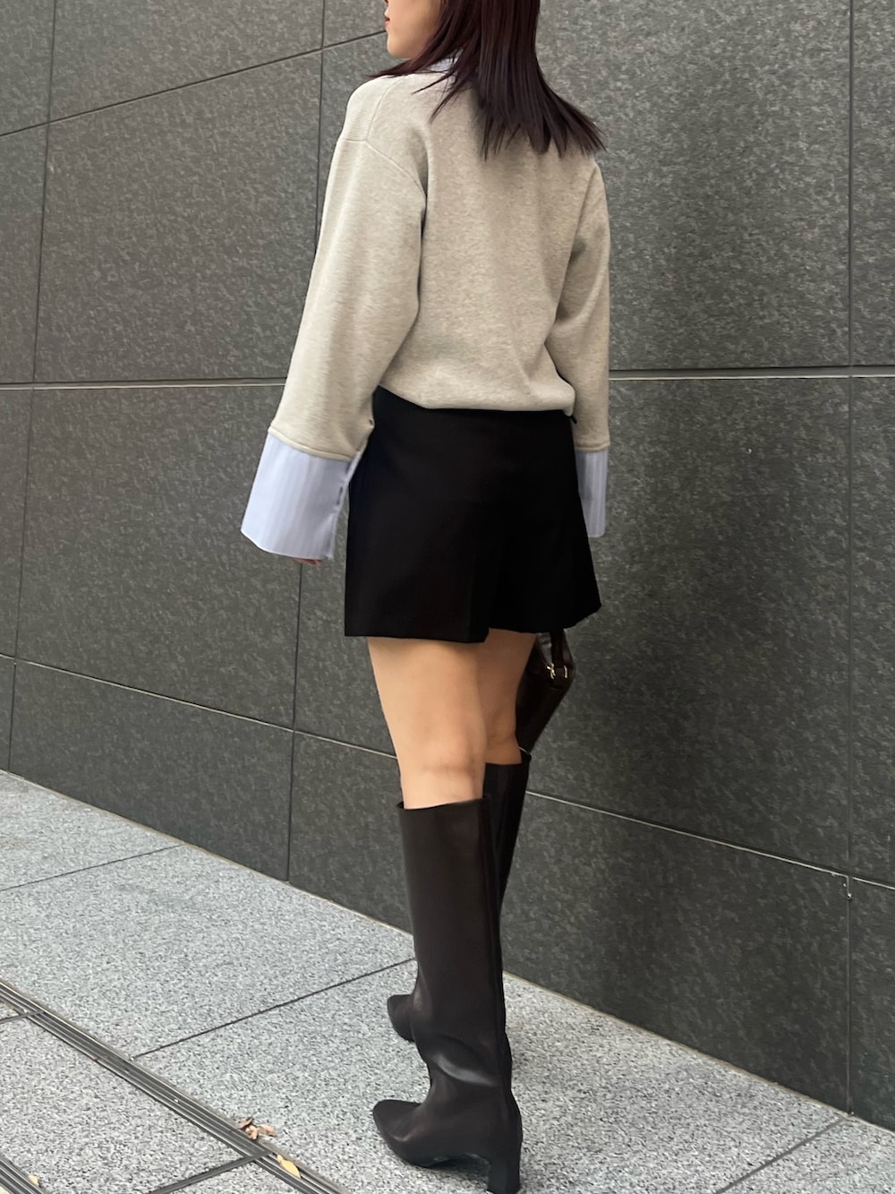 ブラック系のその他パンツ、ブラウン系のハンドバッグ、ブラウン系のブーツを着用したレディースの秋コーディネートの4枚目の写真