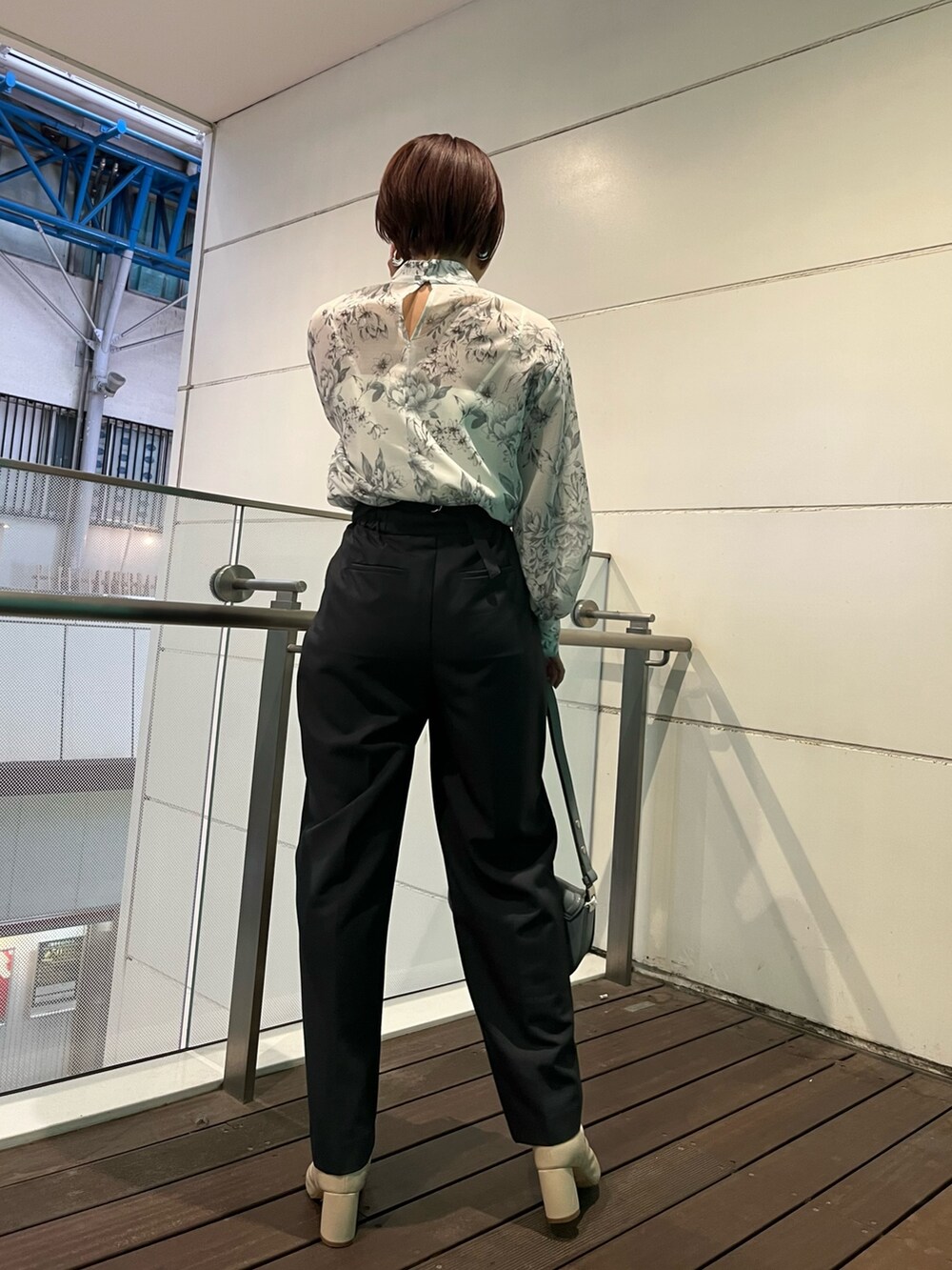 グレー系のシャツ/ブラウス、ブルー系のショルダーバッグ、グレー系のスラックスを着用したレディースの冬コーディネートの3枚目の写真