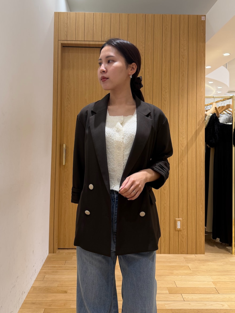 ホワイト系のニット/セーター、ブラウン系のテーラードジャケット、ブルー系のデニムパンツを着用したレディースの春コーディネートの4枚目の写真