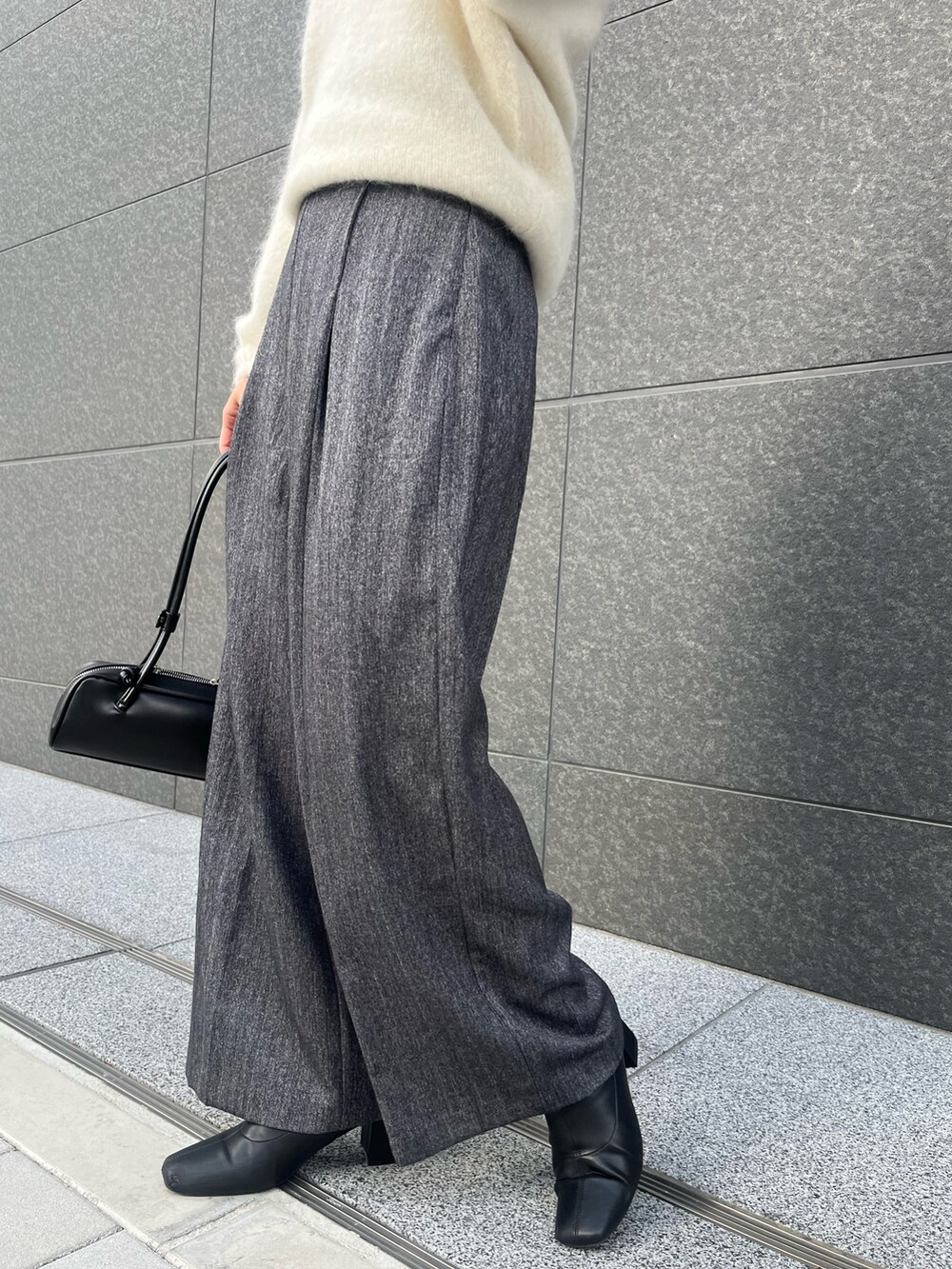 グレー系のその他パンツ、ホワイト系のニット/セーター、ブラック系のショルダーバッグを着用したレディースの冬コーディネートの6枚目の写真