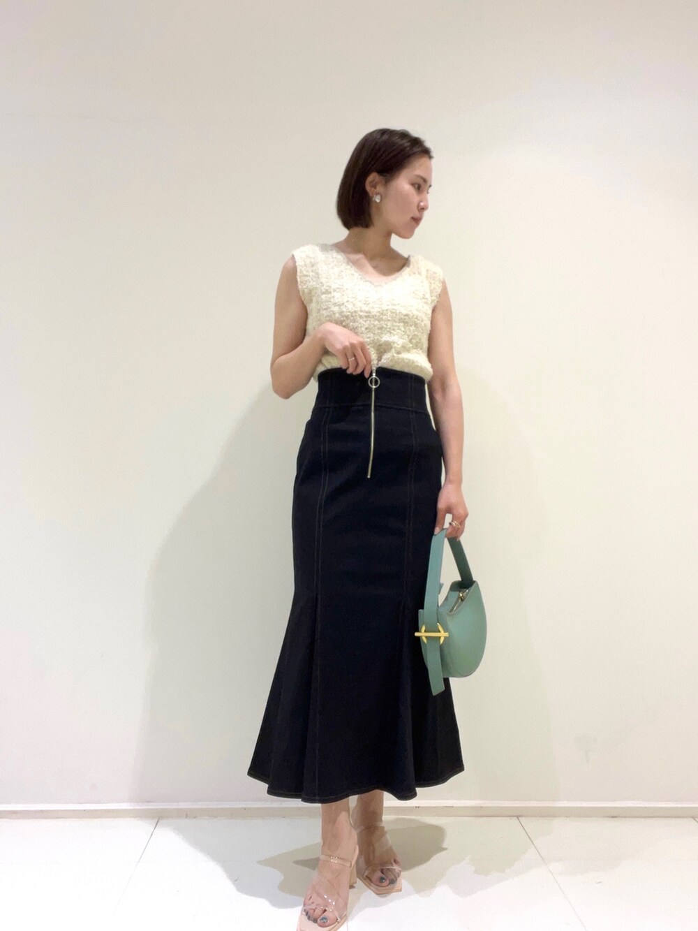 ベージュ系のテーラードジャケット、ホワイト系のニット/セーター、ブラック系のスカートを着用したレディースの春コーディネートの4枚目の写真