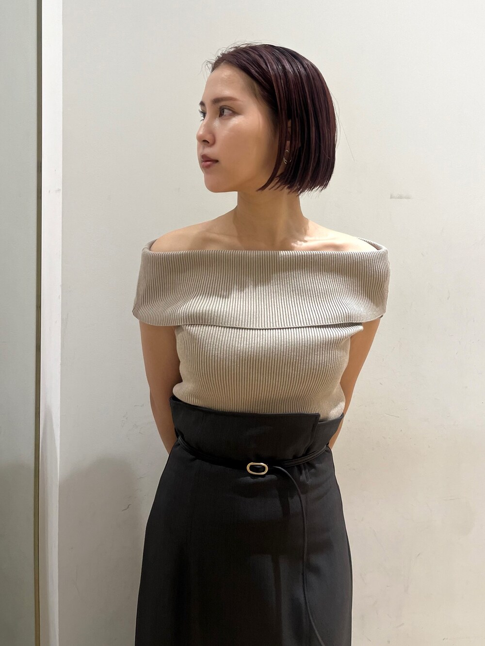 ベージュ系のニット/セーター、ブラック系のサンダル、グレー系のスカートを着用したレディースの夏コーディネートの4枚目の写真