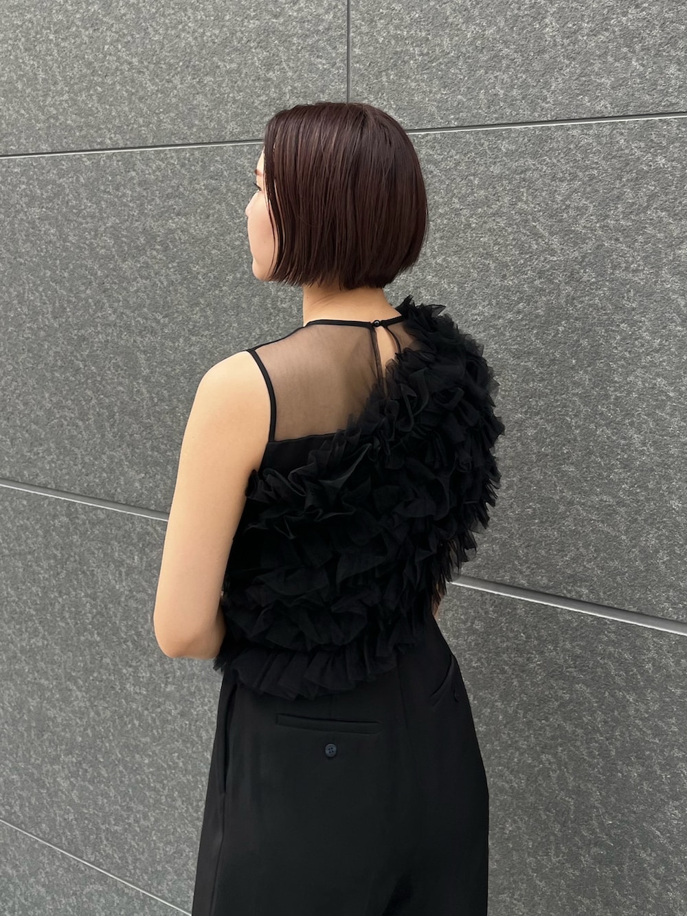 シルバー系のハンドバッグ、ブラック系のパンツドレス、シルバー系のパンプスを着用したレディースの春コーディネートの6枚目の写真