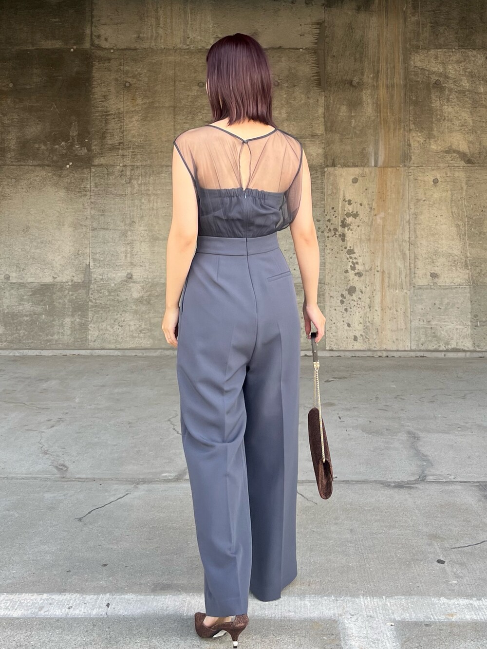 グレー系のパンツドレス、その他のクラッチバッグ、その他のパンプスを着用したレディースの冬コーディネートの3枚目の写真