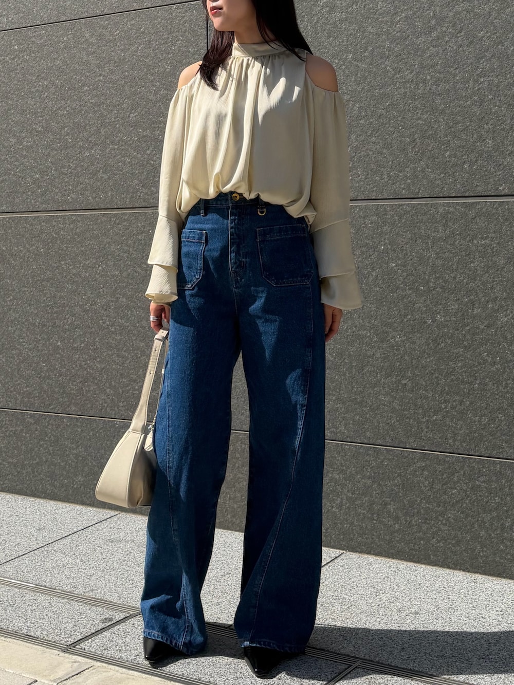 ブルー系のデニムパンツ、グリーン系のシャツ/ブラウス、ブラック系のパンプスを着用したレディースの春コーディネートの4枚目の写真