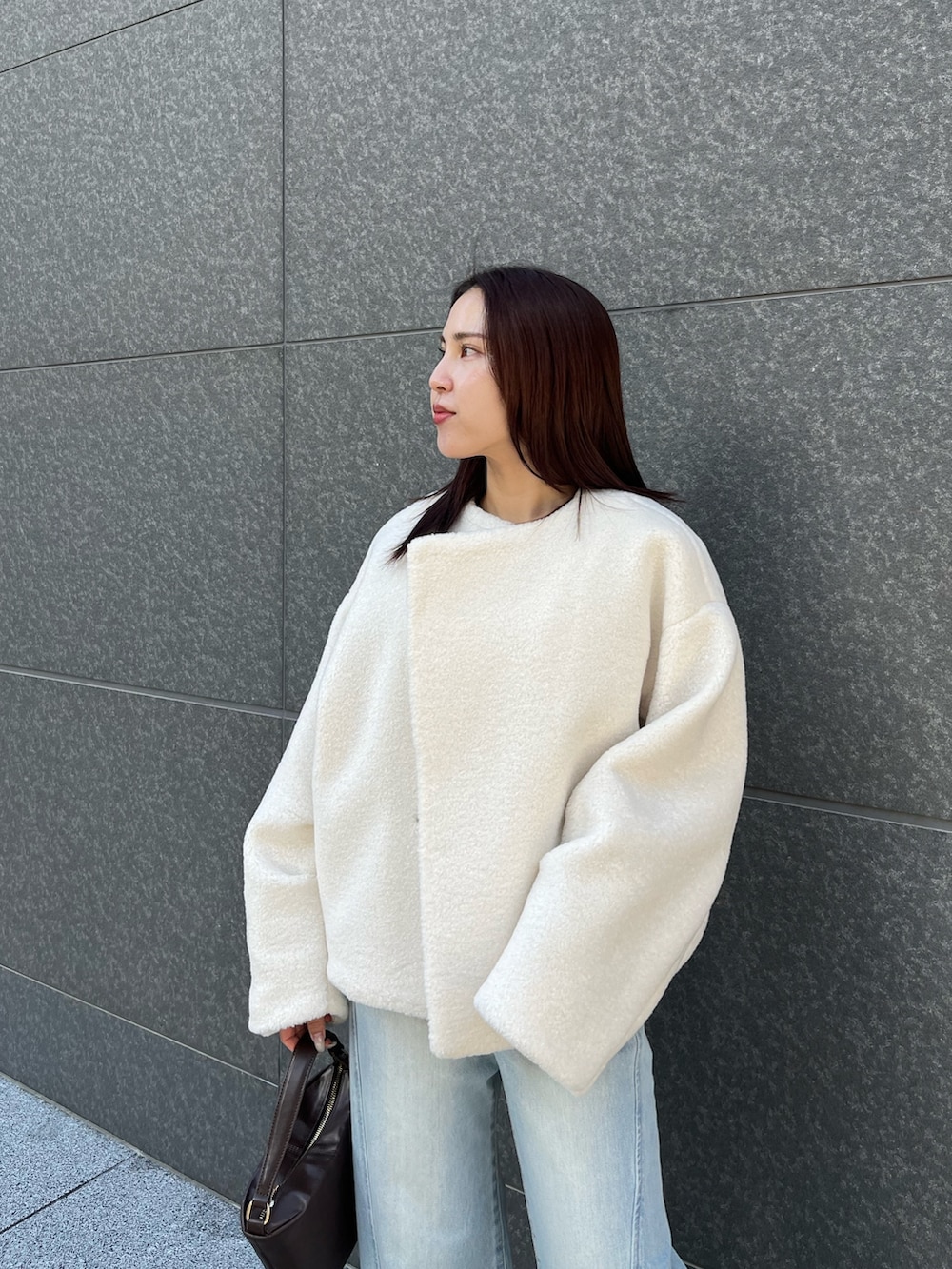 ブルー系のアンサンブル、ブルー系のデニムパンツ、ホワイト系のブルゾンを着用したレディースの冬コーディネートの8枚目の写真