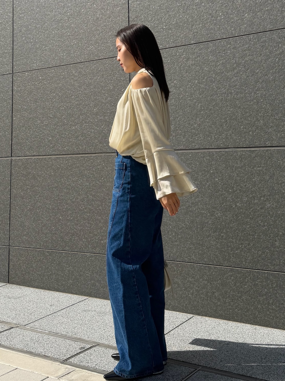 ブルー系のデニムパンツ、グリーン系のシャツ/ブラウス、ブラック系のパンプスを着用したレディースの春コーディネートの2枚目の写真