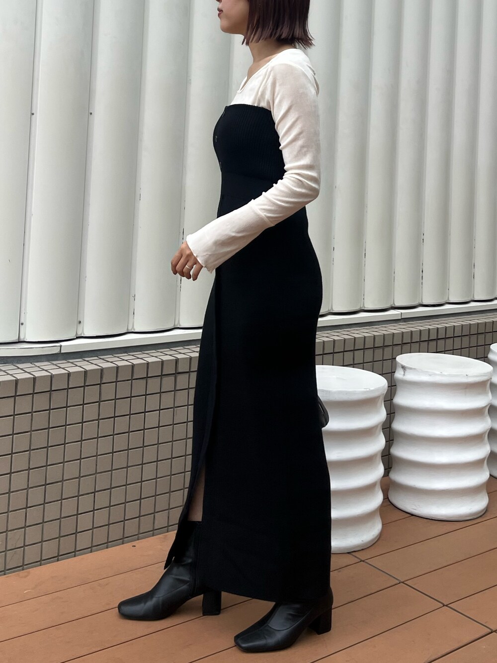 ブラック系のショルダーバッグ、ブラック系のワンピース、ホワイト系のTシャツ/カットソーを着用したレディースの秋コーディネートの3枚目の写真