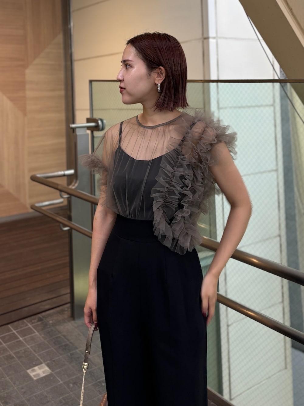 ゴールド系のハンドバッグ、ゴールド系のパンプス、その他のパンツドレスを着用したレディースの秋コーディネートの4枚目の写真