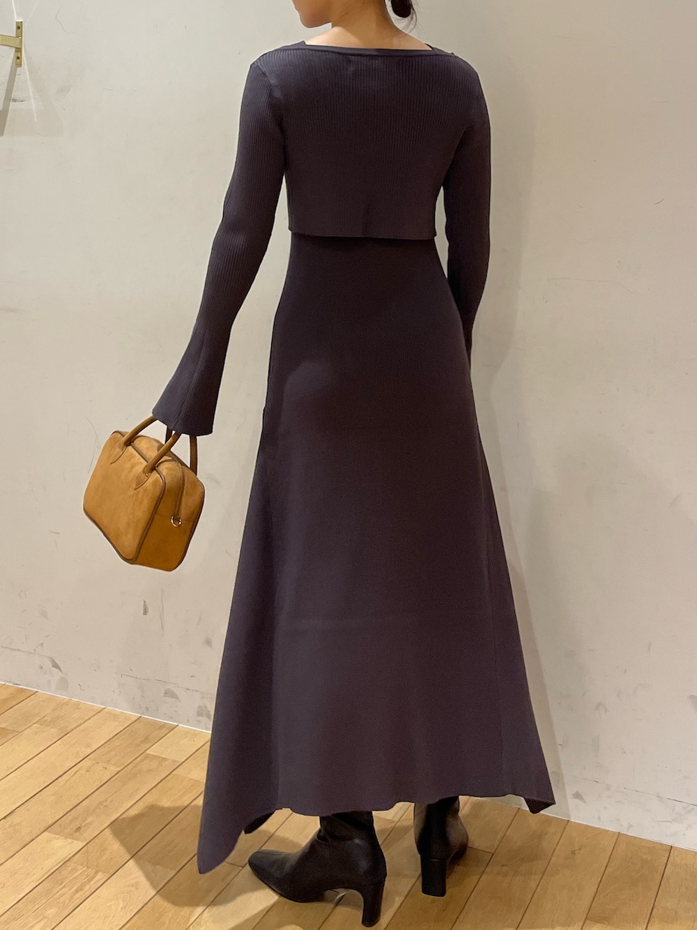 ブラック系のブーツ、グレー系のワンピース、ブラウン系のハンドバッグを着用したレディースの秋コーディネートの3枚目の写真