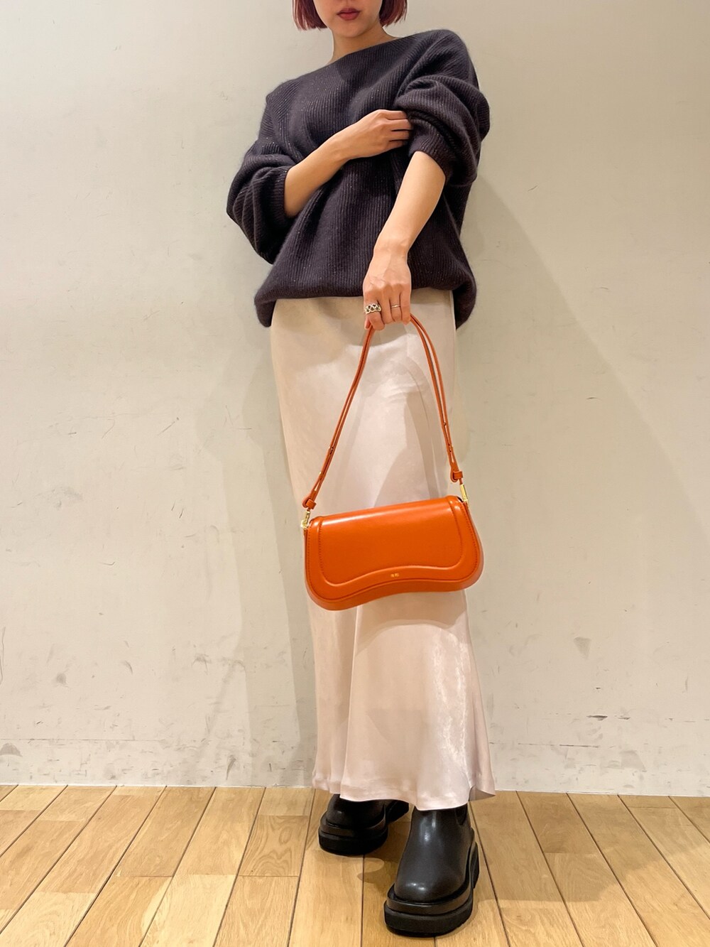 ホワイト系のスカート、オレンジ系のショルダーバッグ、ブラック系のブーツを着用したレディースの秋コーディネートの2枚目の写真