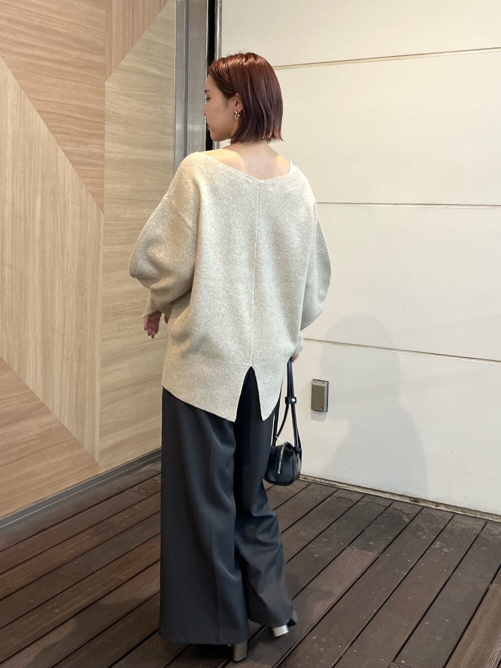 グレー系のその他パンツ、シルバー系のブーツ、ブラック系のショルダーバッグを着用したレディースの秋コーディネートの3枚目の写真