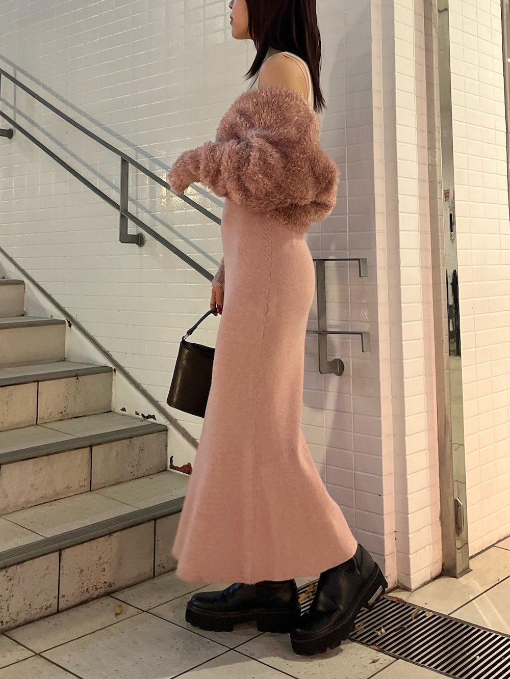 ピンク系のワンピース、ブラウン系のハンドバッグを着用したレディースの冬コーディネートの2枚目の写真