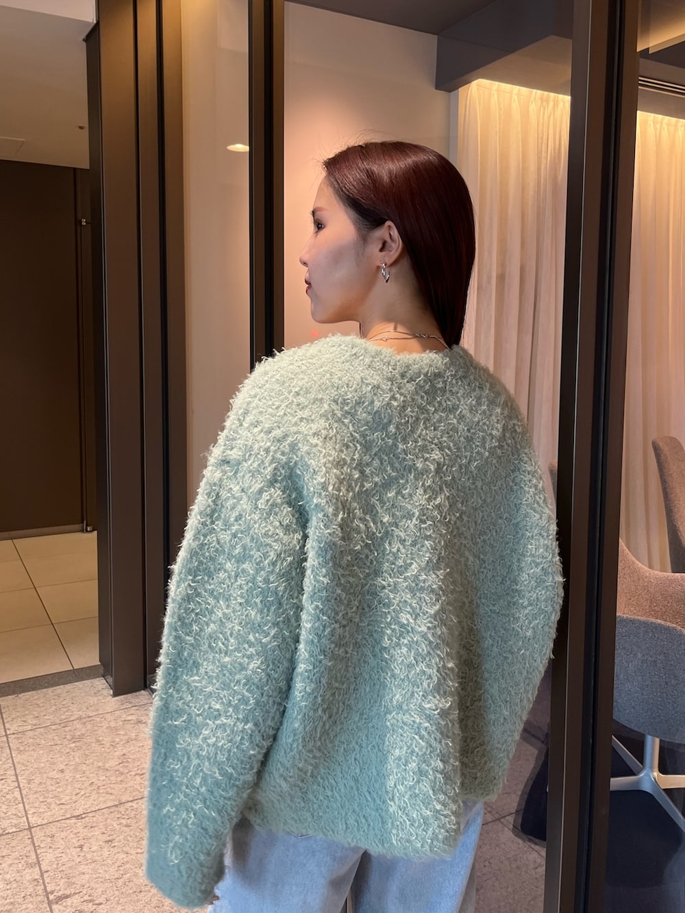 ブルー系のデニムパンツ、ブラウン系のパンプス、ブラウン系のボストンバッグを着用したレディースの夏コーディネートの6枚目の写真