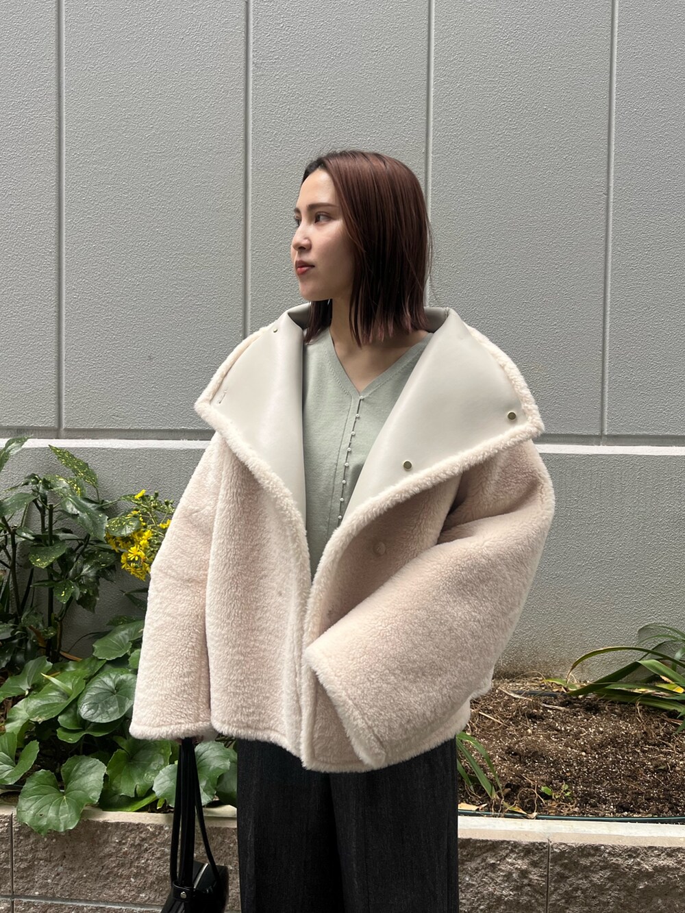 ホワイト系のムートンコート、グレー系のその他パンツ、グリーン系のニット/セーターを着用したレディースの冬コーディネートの8枚目の写真