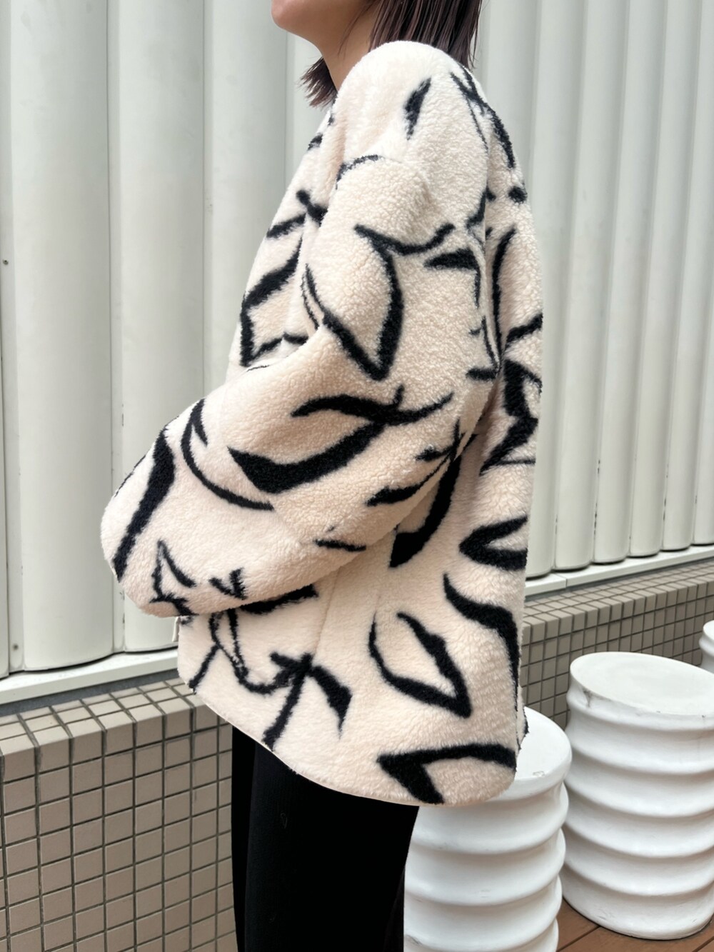 ブラック系のワンピース、ホワイト系のブルゾン、ホワイト系のTシャツ/カットソーを着用したレディースの秋コーディネートの5枚目の写真