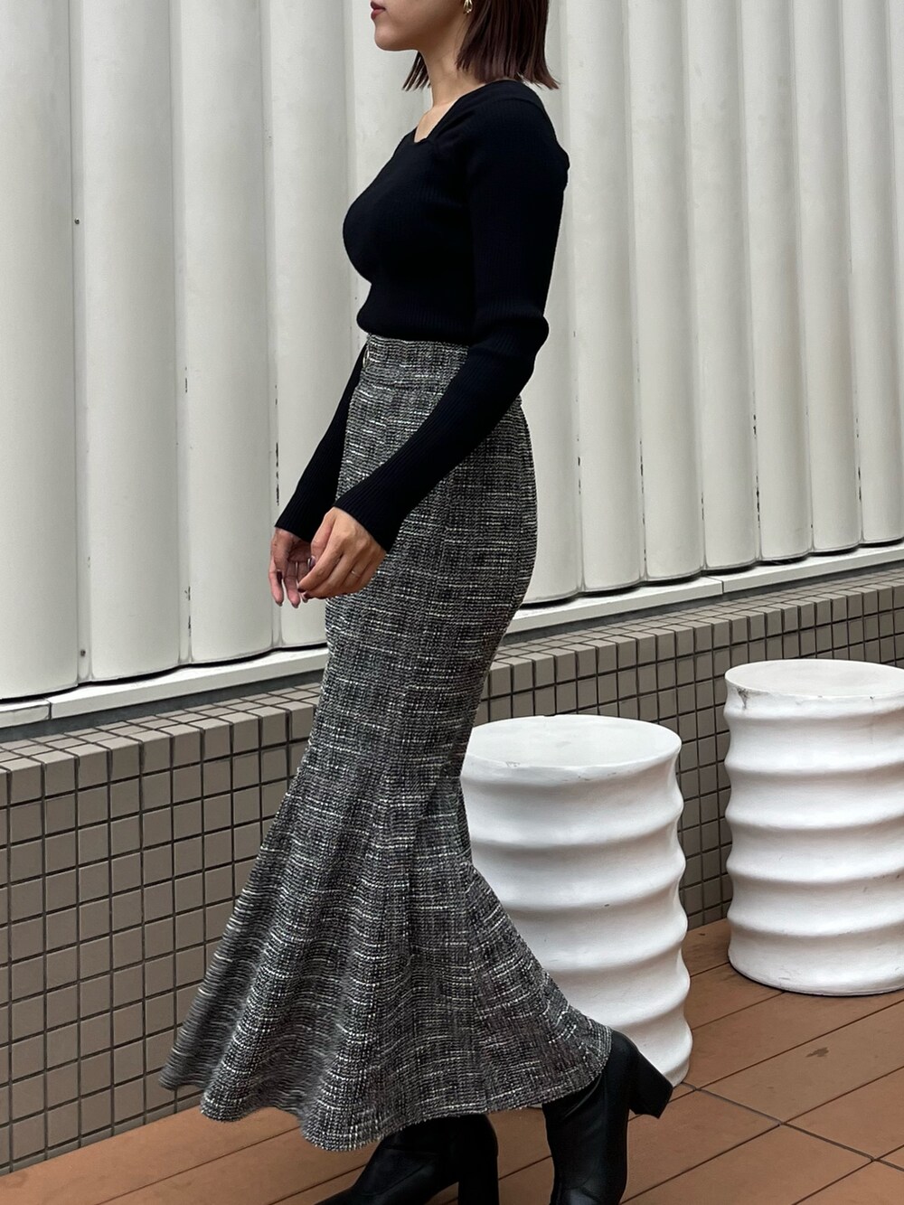 ブラック系のスカート、ブラック系のニット/セーターを着用したレディースの秋コーディネートの2枚目の写真