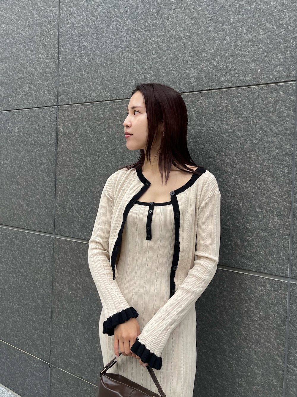 ブラウン系のハンドバッグ、ベージュ系のワンピース、ベージュ系のカーディガン/ボレロを着用したレディースの冬コーディネートの4枚目の写真