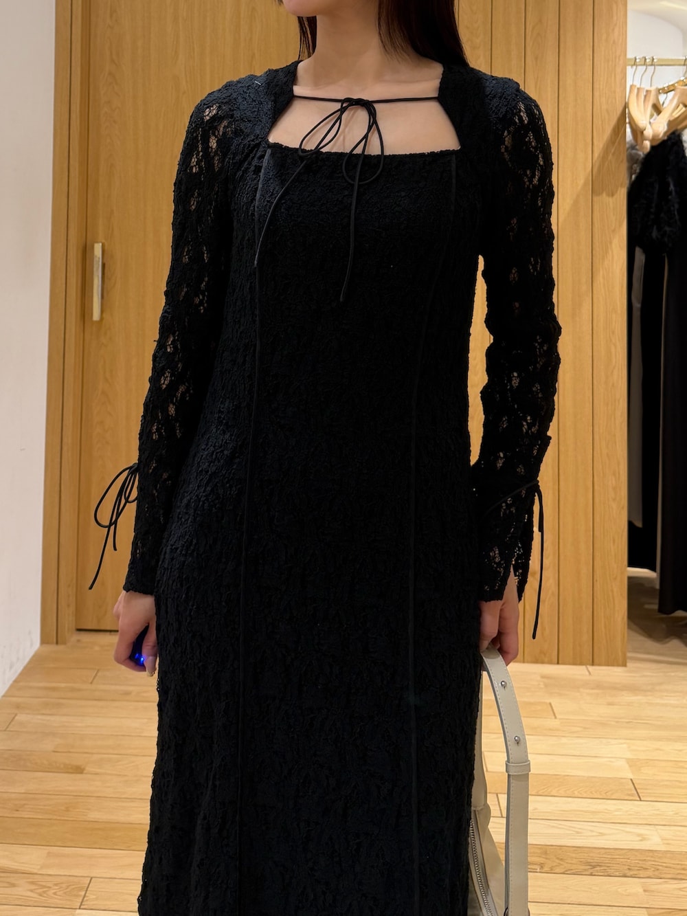 ブラック系のワンピース、ベージュ系のトレンチコートを着用したレディースの春コーディネートの7枚目の写真