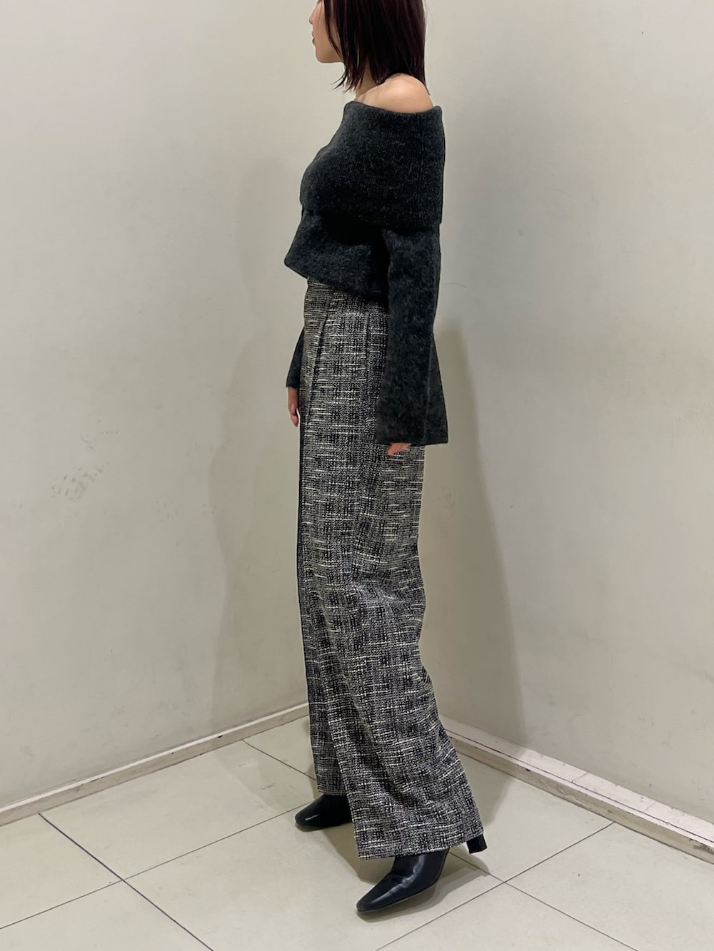 グレー系のニット/セーター、ブラック系のその他パンツ、ブラック系のブーツを着用したレディースの冬コーディネートの2枚目の写真