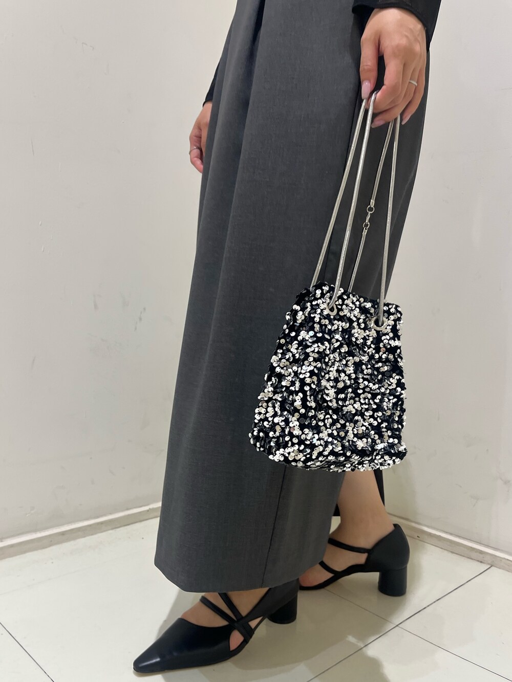 グレー系のドレス、ブラック系のパンプス、シルバー系のハンドバッグを着用したレディースの夏コーディネートの6枚目の写真