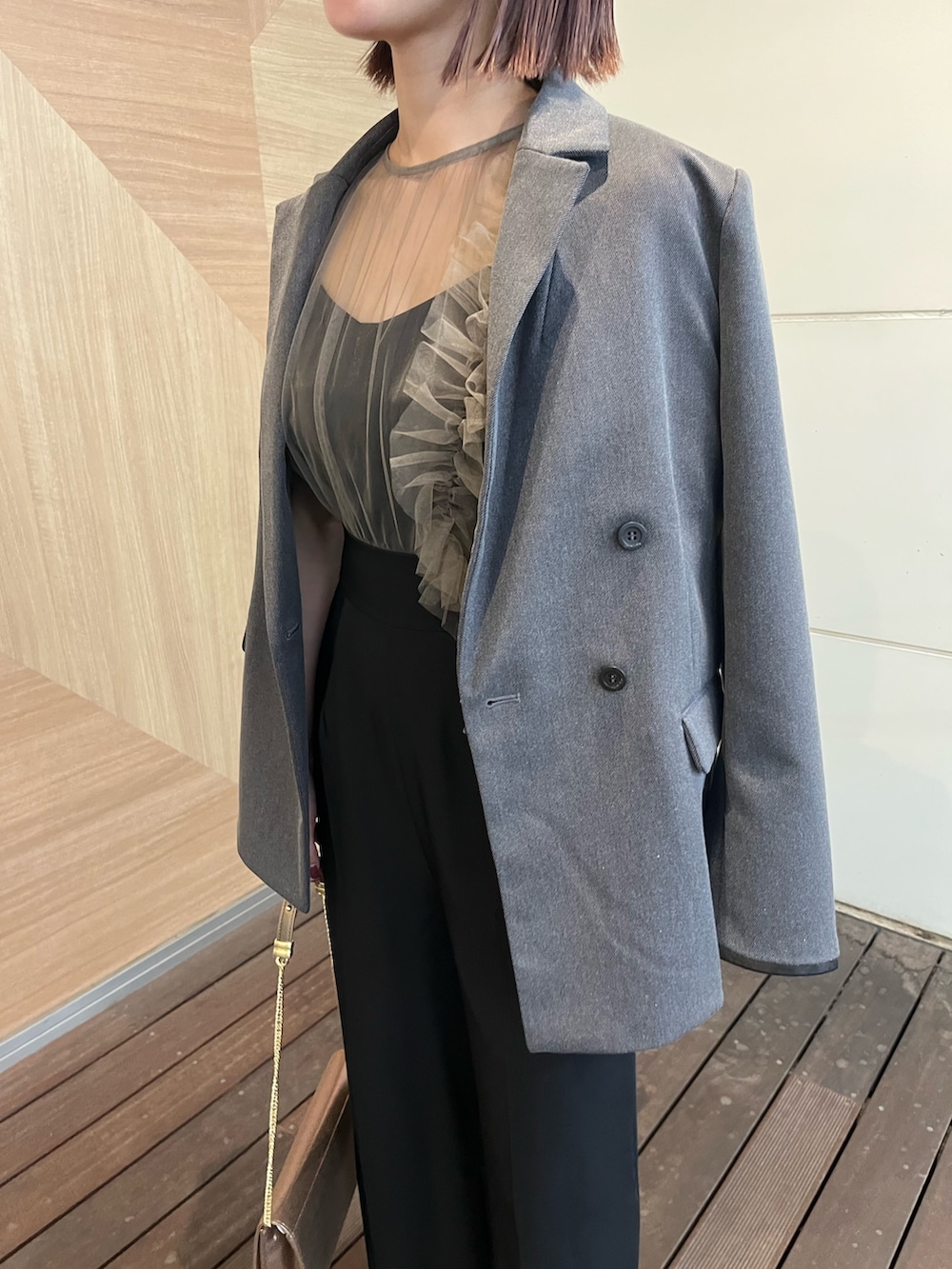 ゴールド系のハンドバッグ、その他のパンツドレス、グレー系のテーラードジャケットを着用したレディースの秋コーディネートの4枚目の写真