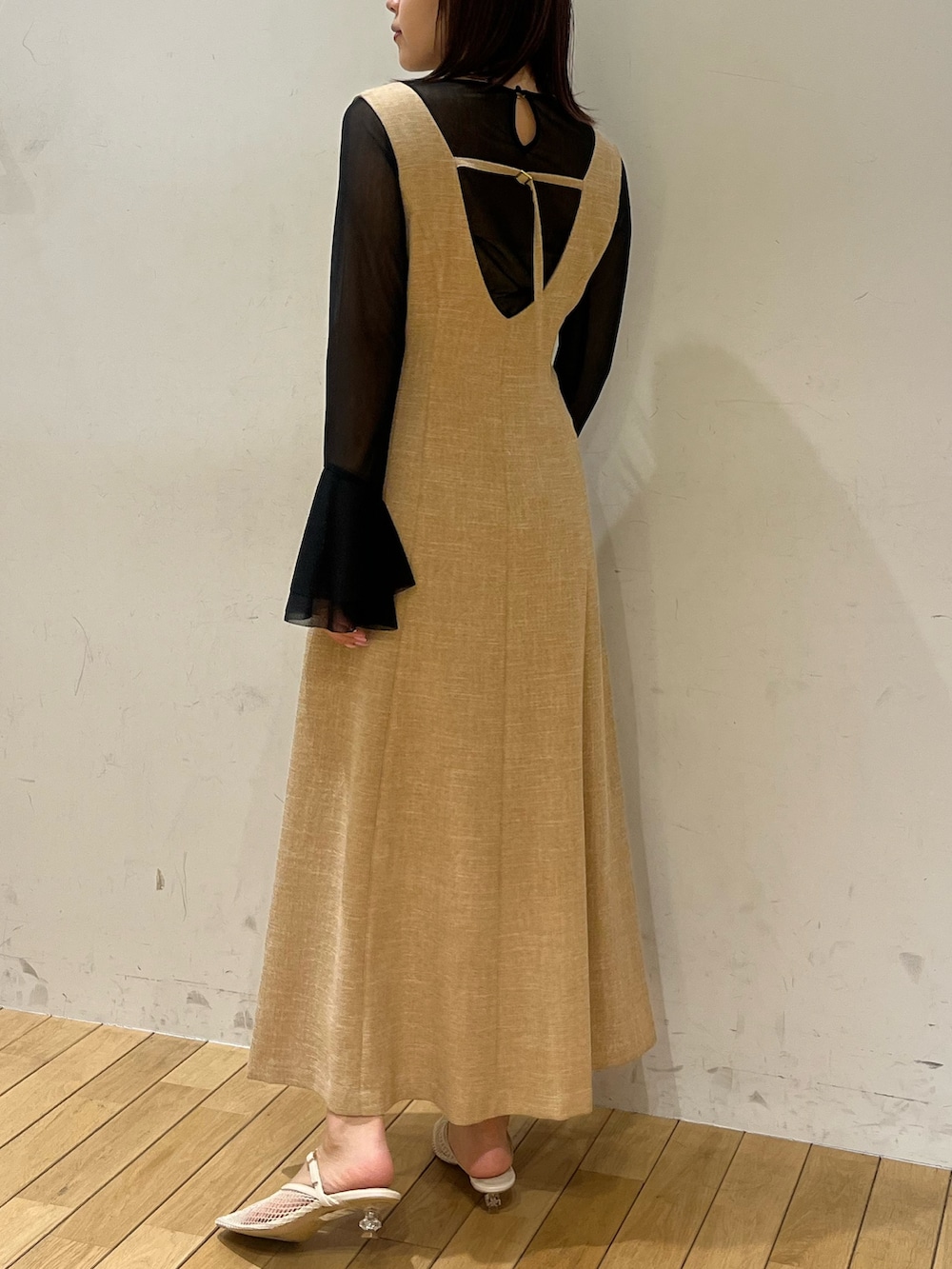 ホワイト系のサンダル、ベージュ系のジャンパースカート、ブラック系のTシャツ/カットソーを着用したレディースの春コーディネートの3枚目の写真