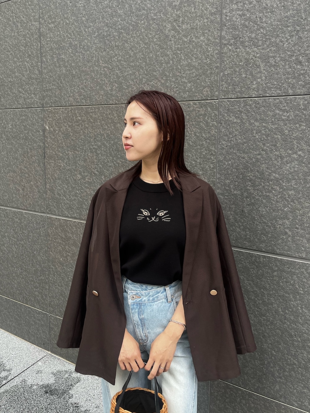 ブラック系のサンダル、ブルー系のデニムパンツ、ブラウン系のテーラードジャケットを着用したレディースの夏コーディネートの4枚目の写真