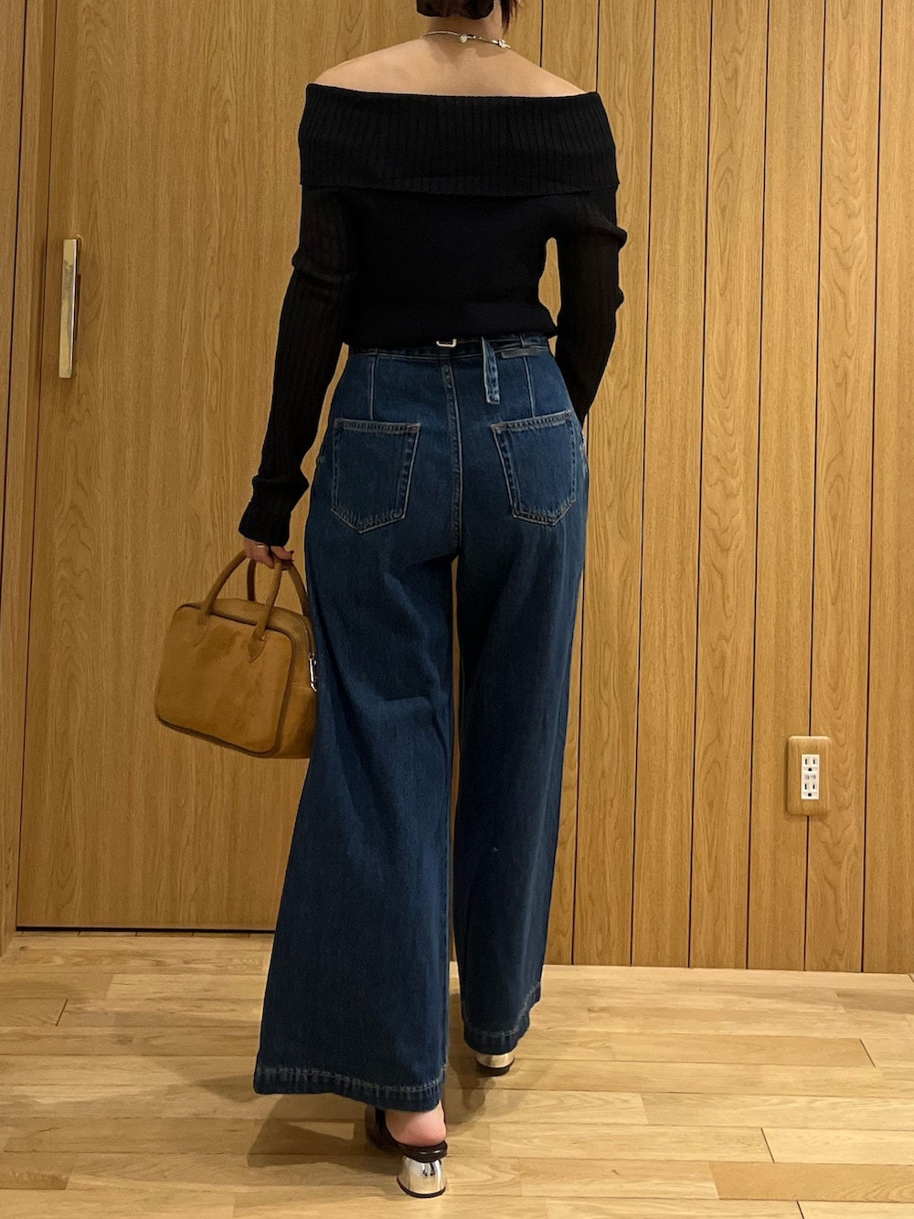 ブラウン系のパンプス、ブラウン系のハンドバッグ、ブルー系のデニムパンツを着用したレディースの秋コーディネートの3枚目の写真