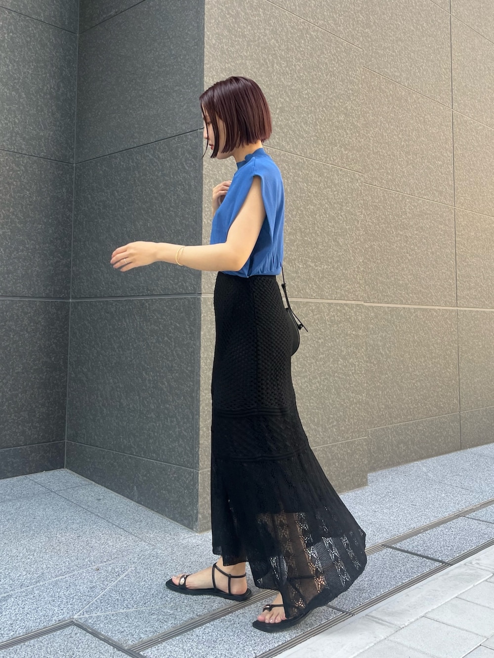 ブラック系のスカート、ブラック系のサンダル、ブラック系のショルダーバッグを着用したレディースの春コーディネートの2枚目の写真