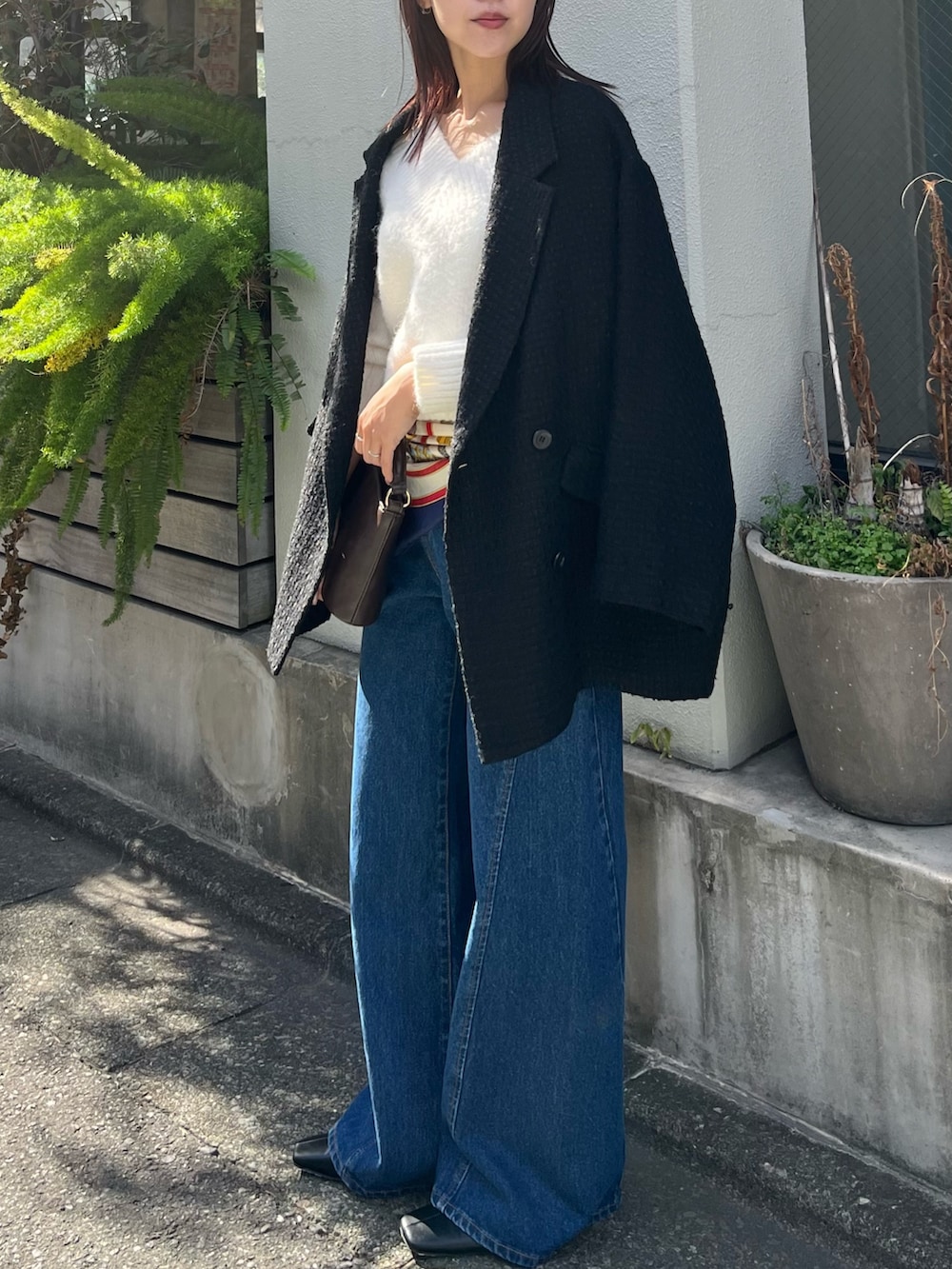 ホワイト系のニット/セーター、ブルー系のデニムパンツ、ブラック系のその他アウターを着用したレディースの冬コーディネートの3枚目の写真