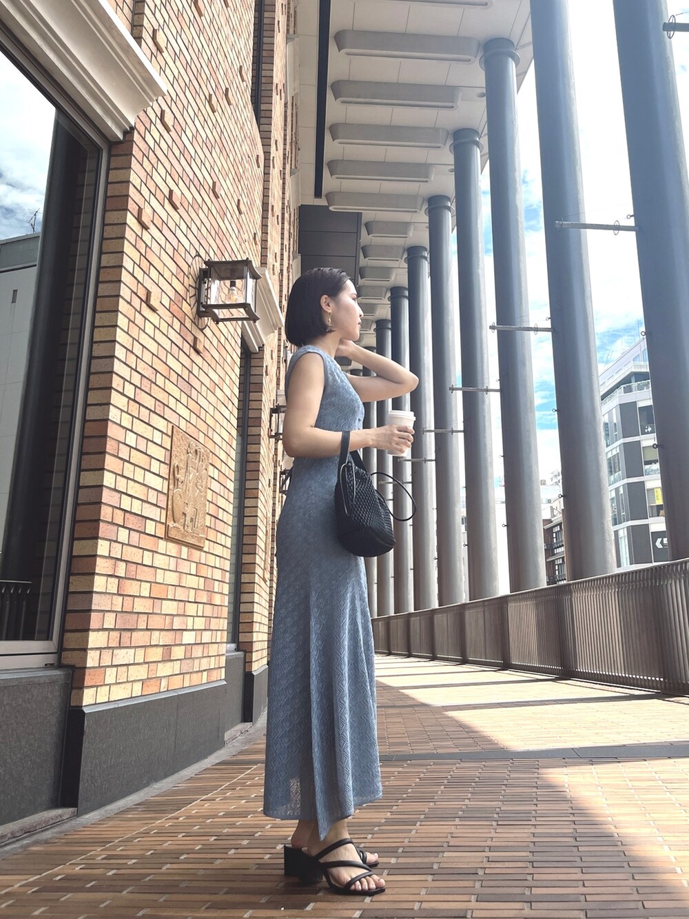 ホワイト系のハンドバッグ、ブルー系のワンピースを着用したレディースの夏コーディネートの2枚目の写真
