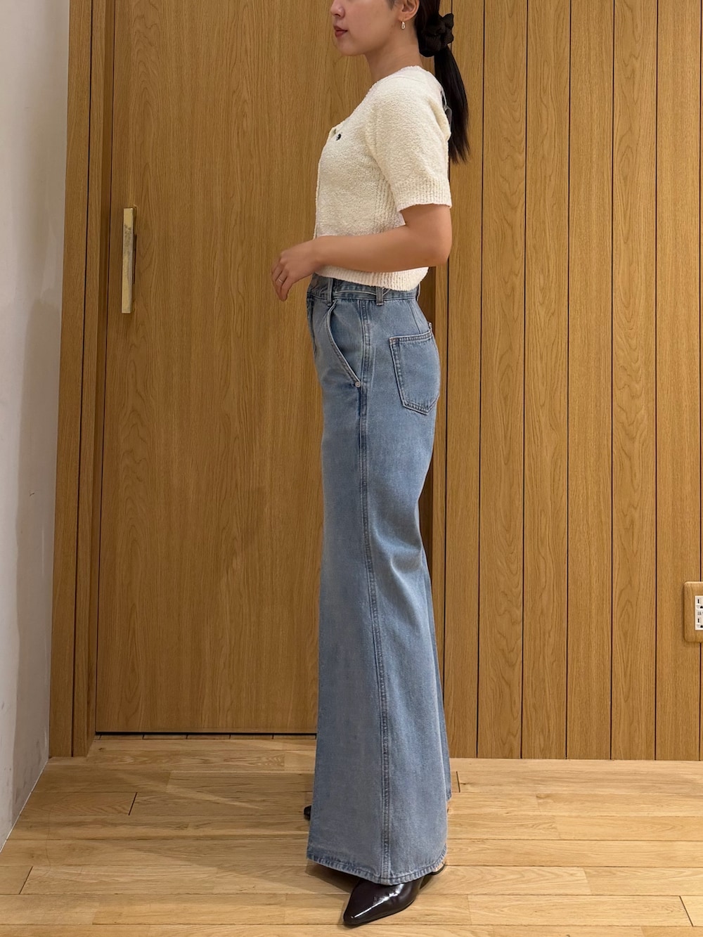 ホワイト系のニット/セーター、ブラウン系のテーラードジャケット、ブルー系のデニムパンツを着用したレディースの春コーディネートの6枚目の写真