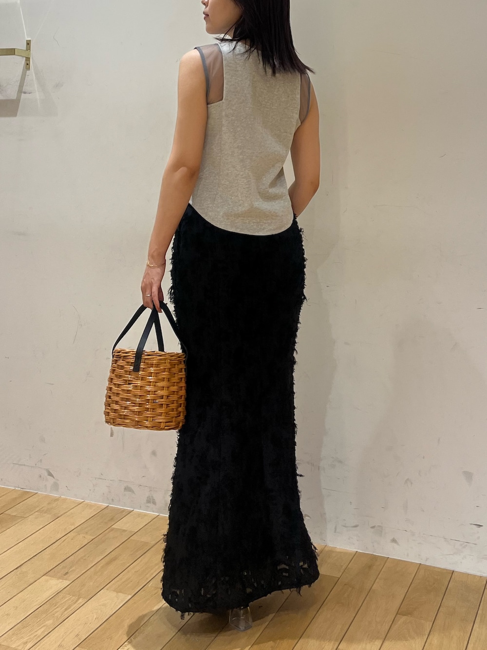 ブラック系のスカート、グレー系のTシャツ/カットソー、ブラウン系のハンドバッグを着用したレディースの夏コーディネートの3枚目の写真