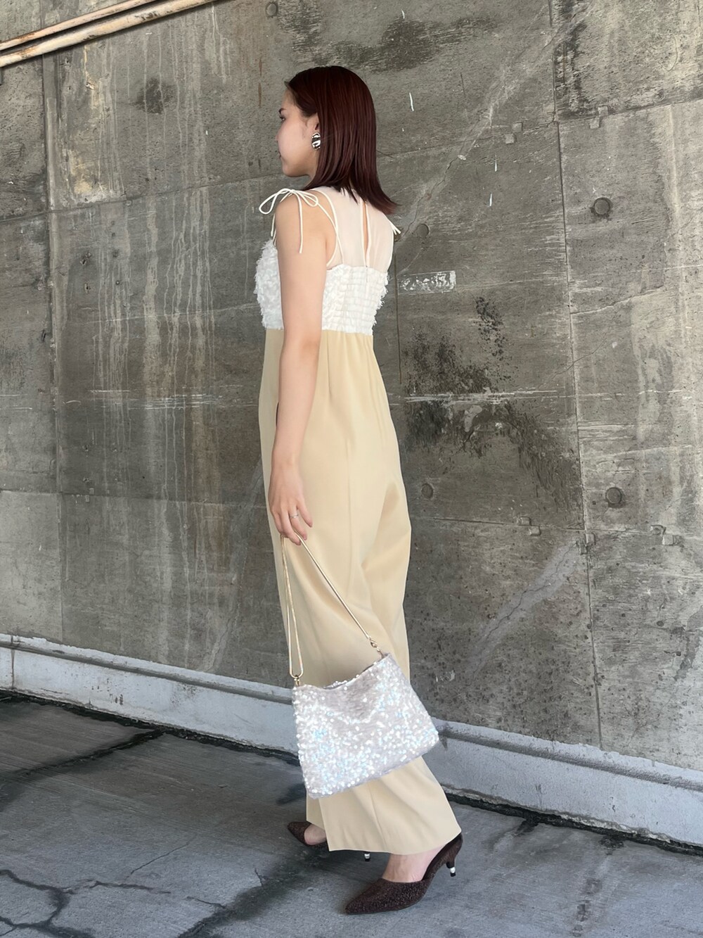 ベージュ系のショルダーバッグ、その他のパンプス、ベージュ系のパンツドレスを着用したレディースの春コーディネートの2枚目の写真