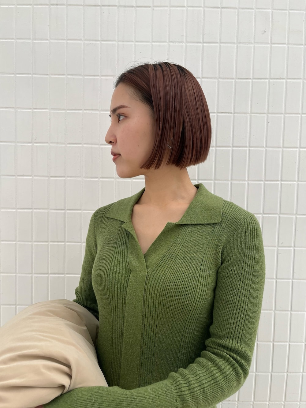 ブラック系のブーツ、ブラック系のハンドバッグ、グリーン系のワンピースを着用したレディースの冬コーディネートの4枚目の写真